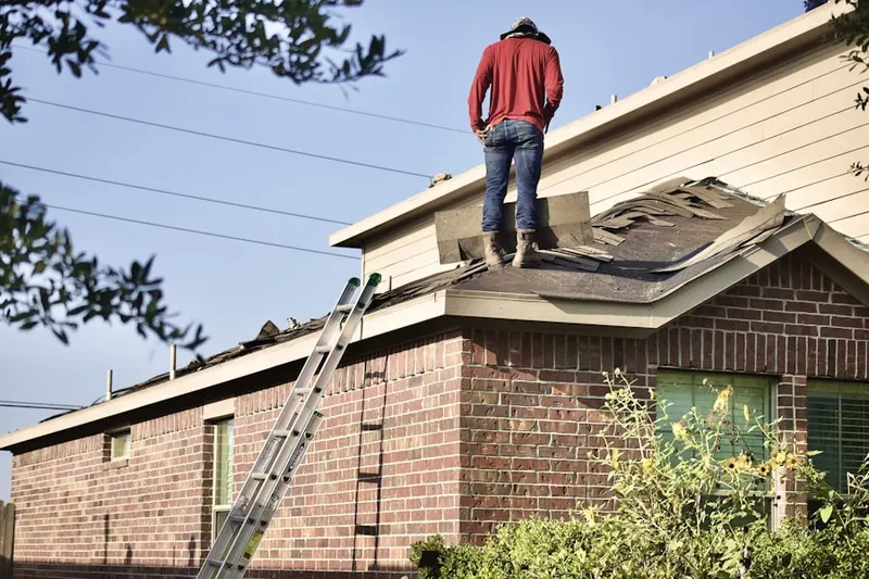 Professional roofer working on a residential roof in Manvel